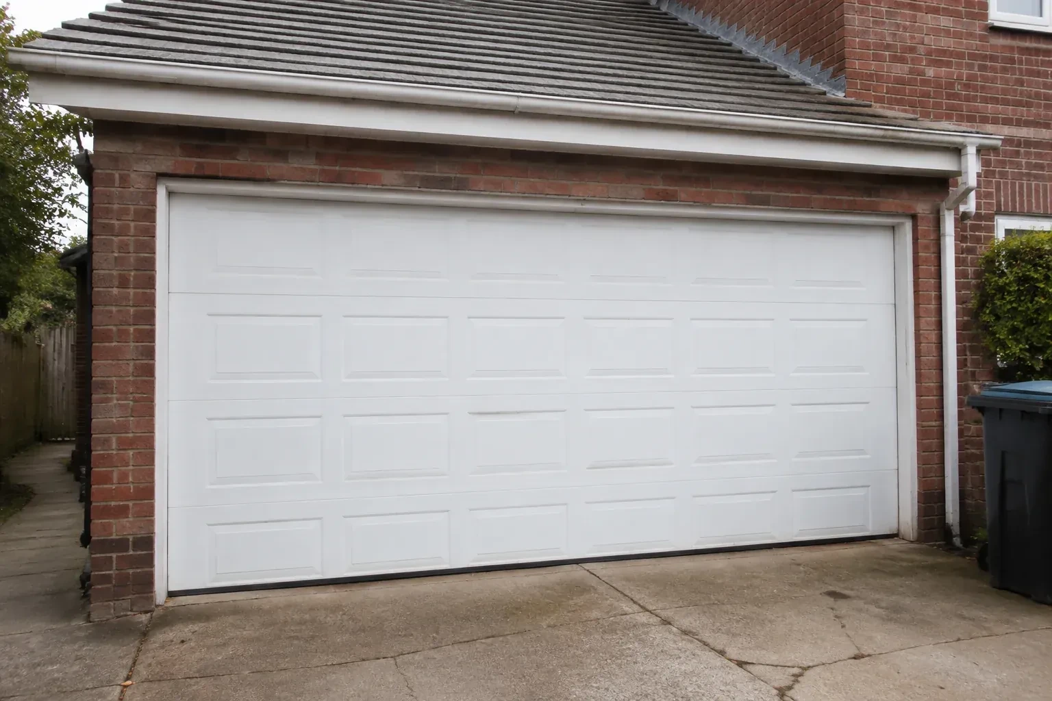 Closed white sectional garage door at an ordinary brick house. — Sectional Garage Door Replacement, Welland